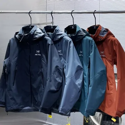 Hooded shell jackets in navy, grey and rust on a clothes rail